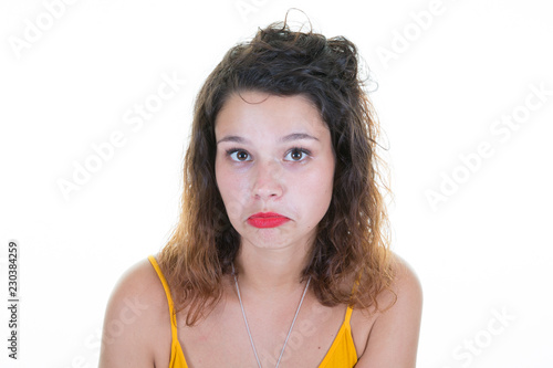 young curly woman pouting and grimacing with her red lips