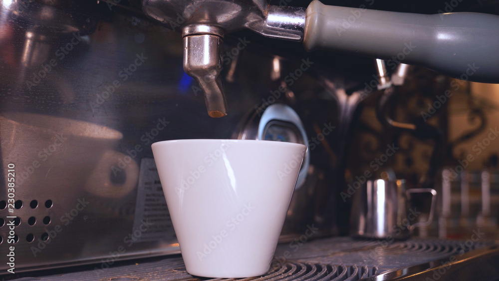 The barman on the coffee machine prepares fresh coffee and adds milk and sugar. Concept from: Barman, Coffee, Sugar, Coffee Machine, Man, Tattoo, Good morning.