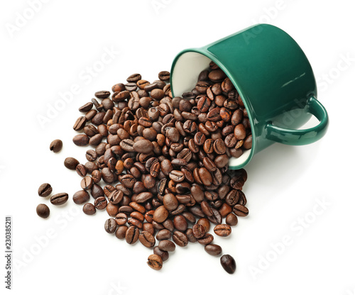 Overturned cup with coffee beans on white background