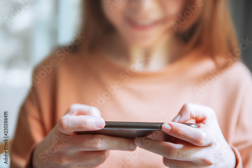Close up of woman hands playing a game on a mobile smartphone.