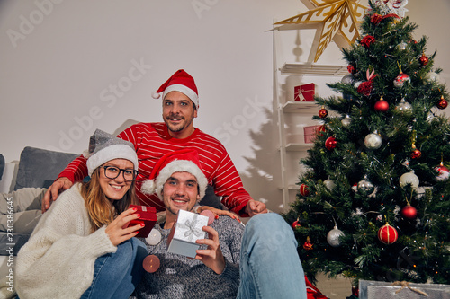 Three friends sharing Cristmas / New Year's eve  presents.