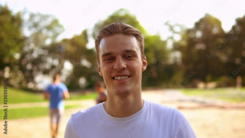 smiling caucasian man walking looking at the camera. handsome young male laughing outdoors slow motion smiling caucasian man walking looking at the camera. handsome young male laughing outdoors slow motion