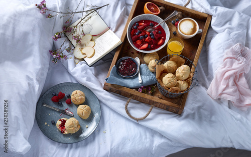 Wooden tray with breakfast on bed