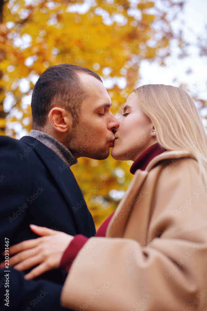 Girl and man or lovers on date hug. Couple in love in park . Autumn. Man and woman smile on autumn fallen leaves in a park, enjoying a beautiful autumn day. Young couple in the autumn. Kiss Girl and man or lovers on date hug. Couple in love in park . Autumn. Man and woman smile on autumn fallen leaves in a park, enjoying a beautiful autumn day. Young couple in the autumn. Kiss