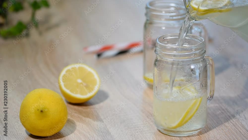 Pouring homemade lemonade in glass jar. Pouring homemade lemonade in glass jar.