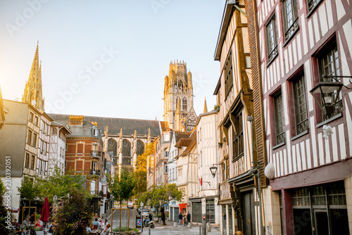 Street view with beautiful old buildings and cathedral tower on the background in Rouen city, the capital of Normandy region in France