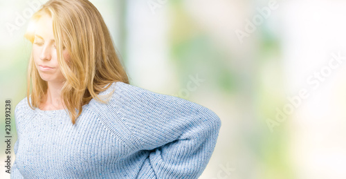 Beautiful young woman wearing blue sweater over isolated background Suffering of backache, touching back with hand, muscular pain