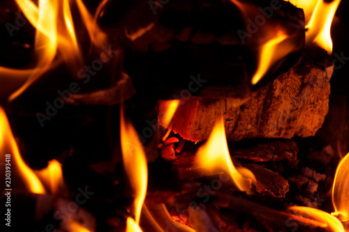 burning red wood, charcoal covered with fire