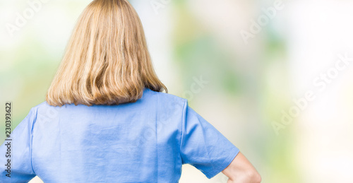 Beautiful young doctor woman wearing medical uniform over isolated background standing backwards looking away with arms on body