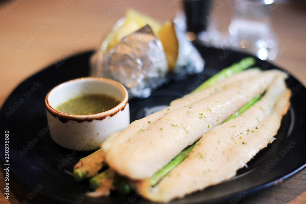 Prepared grilled basa fish fillet with baked potatoes and seafood