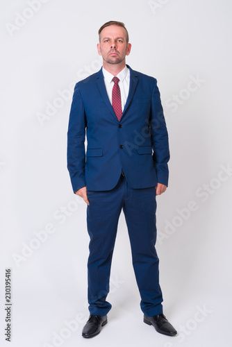 Full body shot of blonde businessman wearing blue suit