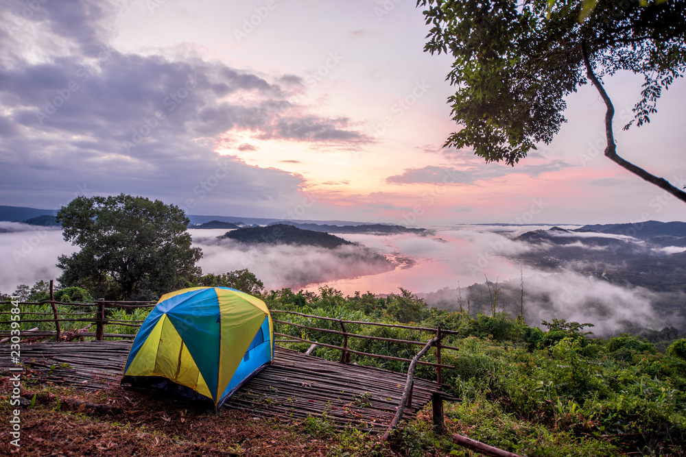 Tent camping on top of mountain whit mist fog background during morning time 