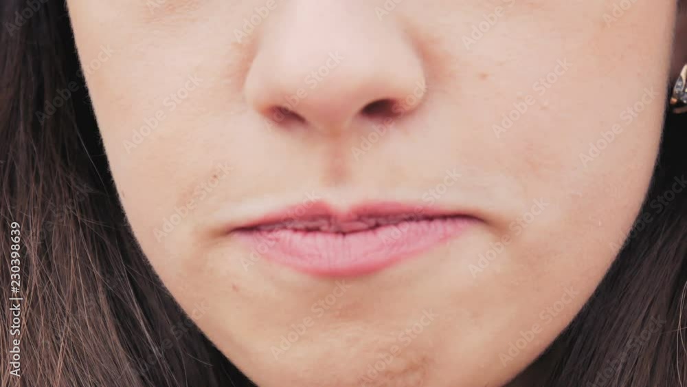 The girl with lipstick makeup eats yogurt from a spoon. Close up. The girl with lipstick makeup eats yogurt from a spoon. Close up.