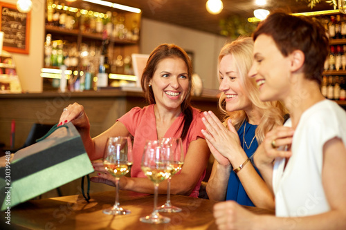 people, leisure and lifestyle concept - women with shopping bags at wine bar or restaurant