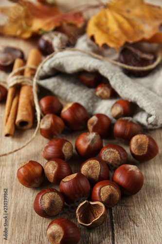A placer of hazelnuts on a wooden background. Rustic. Christmas. Close up. Cinnamon sticks. Festive athmosphere