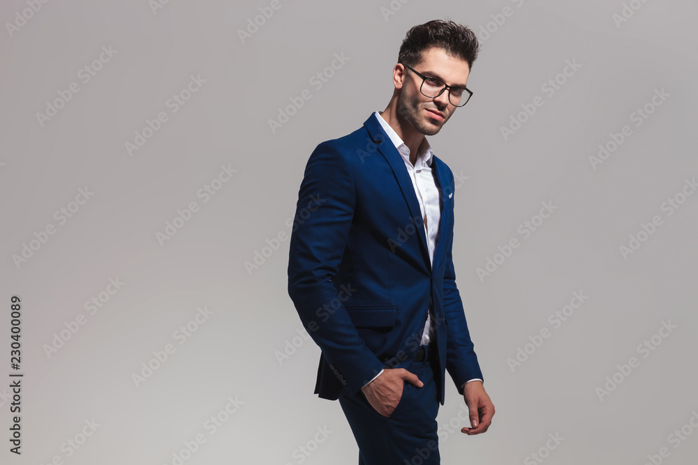 Fototapeta premium smiling elegant man wearing glasses stands with hand in pocket