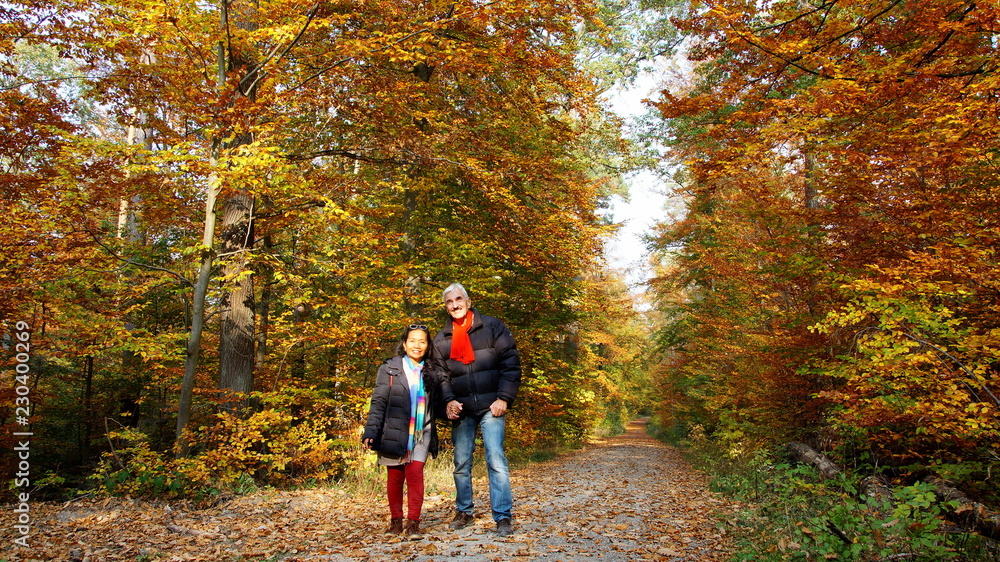 Obraz premium reifes Paar wandert verliebt durch bunten Herbstwald