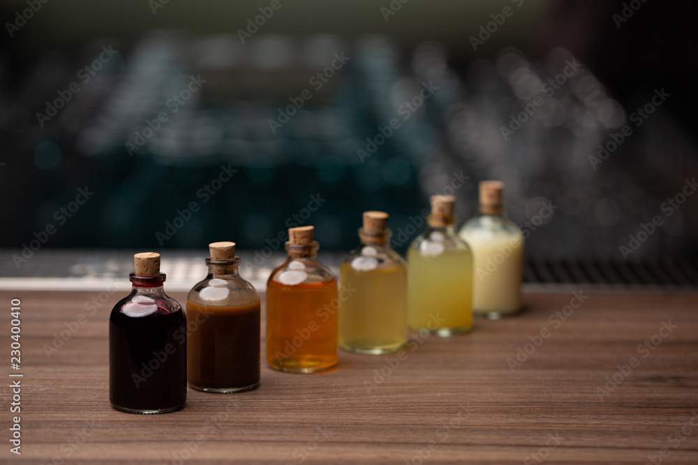 glass jars with colored liquid on the wooden table