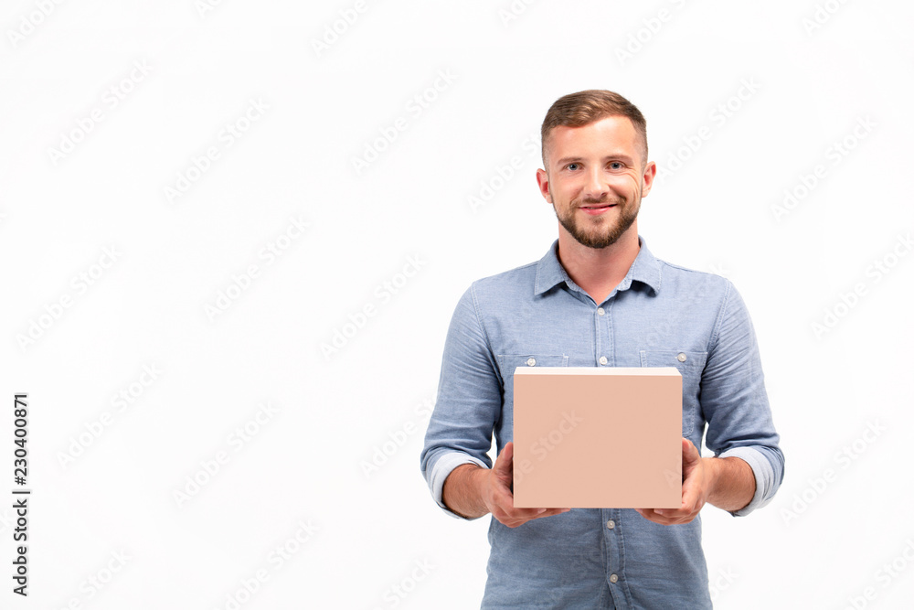 Casual young man holding a box isolated on a white background Casual young man holding a box isolated on a white background