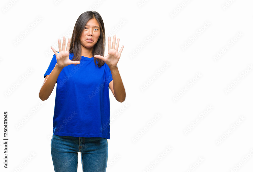 Young asian woman over isolated background afraid and terrified with fear expression stop gesture with hands, shouting in shock. Panic concept. Young asian woman over isolated background afraid and terrified with fear expression stop gesture with hands, shouting in shock. Panic concept.