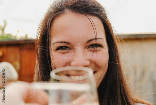 Pretty young woman enjoying a glass of wine with friends. photo
