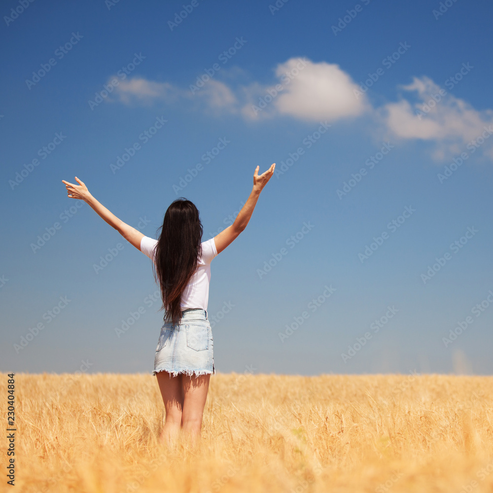 Happy woman enjoying the life in the field Nature beauty, blue cloudy sky and colorful field with golden wheat. Outdoor lifestyle. Freedom concept. Woman in summer field Happy woman enjoying the life in the field Nature beauty, blue cloudy sky and colorful field with golden wheat. Outdoor lifestyle. Freedom concept. Woman in summer field