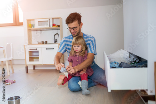 Father putting daughters socks on