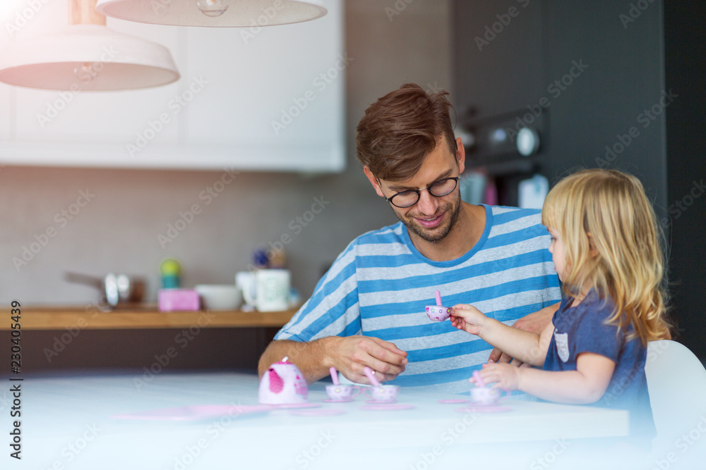 Father and daughter having a tea party at home
Father and daughter having a tea party at home