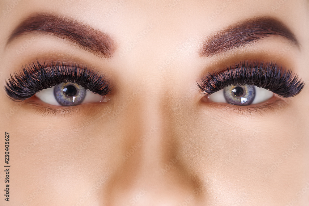 Eyelash Extension Procedure. Woman Eye with Long Eyelashes. Close up, selective focus. Hollywood, russian volume Eyelash Extension Procedure. Woman Eye with Long Eyelashes. Close up, selective focus. Hollywood, russian volume