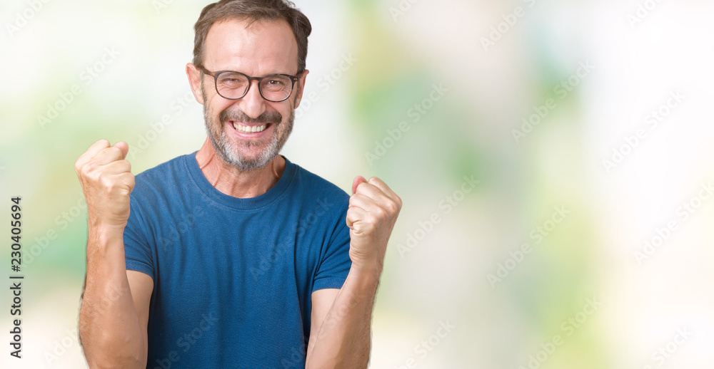 Handsome middle age hoary senior man wearin glasses over isolated background celebrating surprised and amazed for success with arms raised and open eyes. Winner concept. Handsome middle age hoary senior man wearin glasses over isolated background celebrating surprised and amazed for success with arms raised and open eyes. Winner concept.