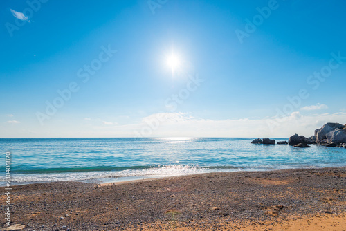 A bright midday sun over clear sea water, a view of the horizon. Seascape