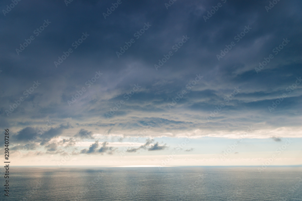 Large heavy black cloud dramatic sky above the sea surface of water