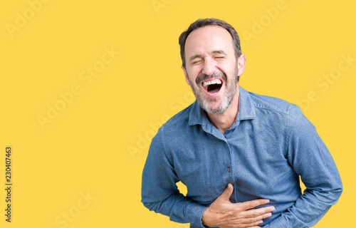 Fototapeta Handsome middle age elegant senior man over isolated background Smiling and laughing hard out loud because funny crazy joke
