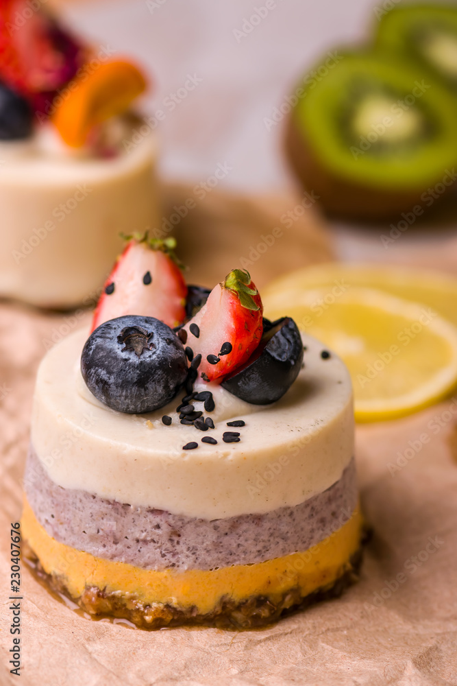Cake with fruits and berries close-up. White dessert on a wooden table.