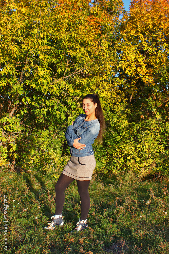 A young girl in the autumn forest at sunset A young girl in the autumn forest at sunset