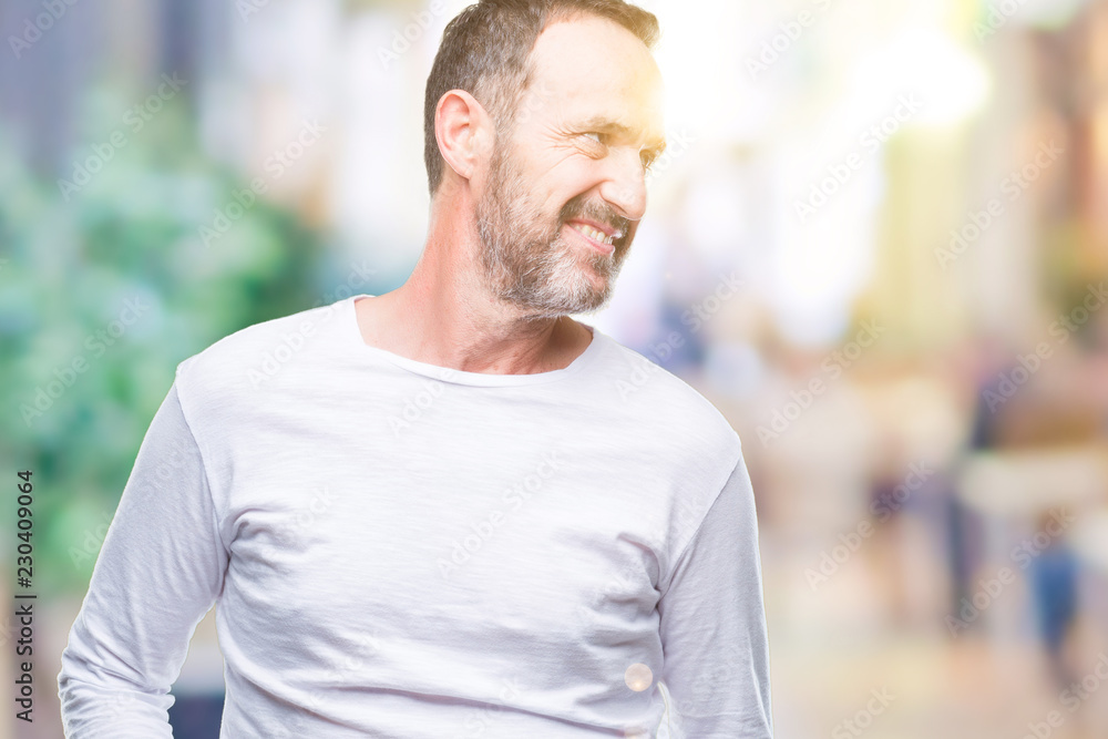 Middle age hoary senior man wearing white t-shirt over isolated background looking away to side with smile on face, natural expression. Laughing confident. Middle age hoary senior man wearing white t-shirt over isolated background looking away to side with smile on face, natural expression. Laughing confident.