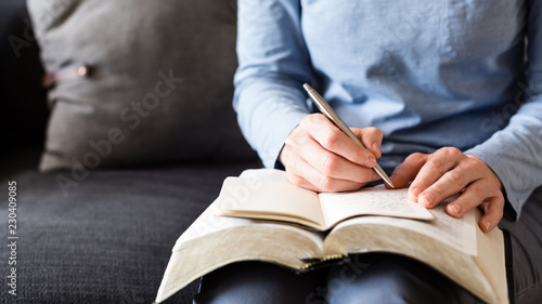 Bible Study - Woman Taking Notes as She Reads from an Open Bible