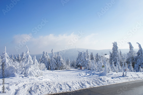 Winterlandschaft / Wanderer auf dem Fichtelberg im Erzgebirge, Blick zum Klinovec in Tschechien, dick verschneite Fichten, blauer Himmel und Wolken