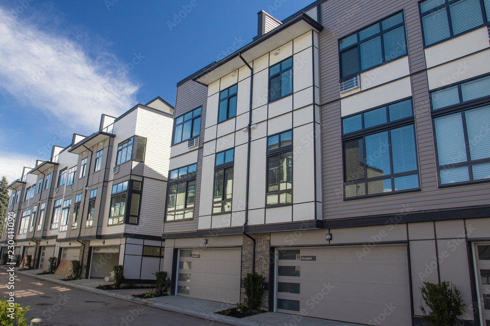 Brand new townhouse complex. Rows of townhomes side by side. External facade of a row of colorful modern urban townhouses. brand new houses just after construction on real estate market