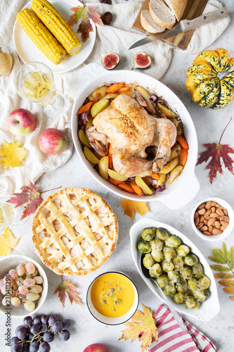 Thanksgiving dinner with chicken, apple pie, pumpkin soup brussel sprouts and fruits.