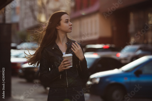 Woman enjoying to walking with coffee cup in city street