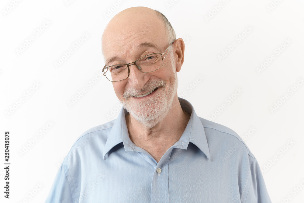 People, age, positiveness, joy and happiness concept. Handsome cute elderly man wearing blue shirt and rectangular eyeglasses smiling broadly, laughing at his own joke, expressing positive emotions People, age, positiveness, joy and happiness concept. Handsome cute elderly man wearing blue shirt and rectangular eyeglasses smiling broadly, laughing at his own joke, expressing positive emotions