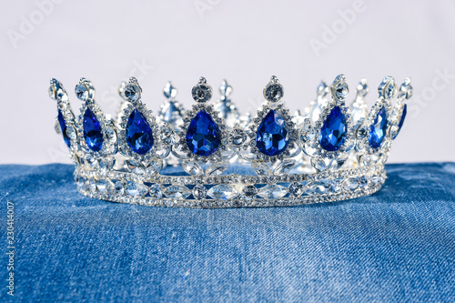 Obraz na płótnie Herrliche Krone mit blauen Steinen auf Blue Jeans Stoff glitzern und funkeln