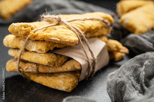 homemade pastries, fresh pumpkin cookies stacked in stacks, and tied with a slice on a dark background photo