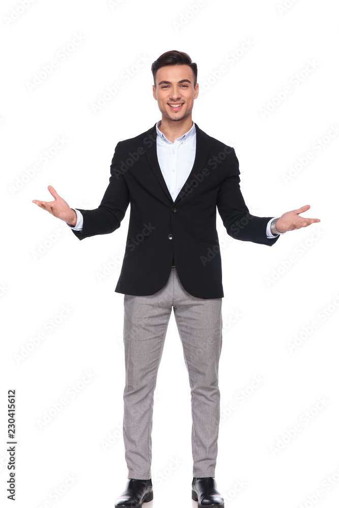 smiling businessman in black suit making an open hand gesture smiling businessman in black suit making an open hand gesture