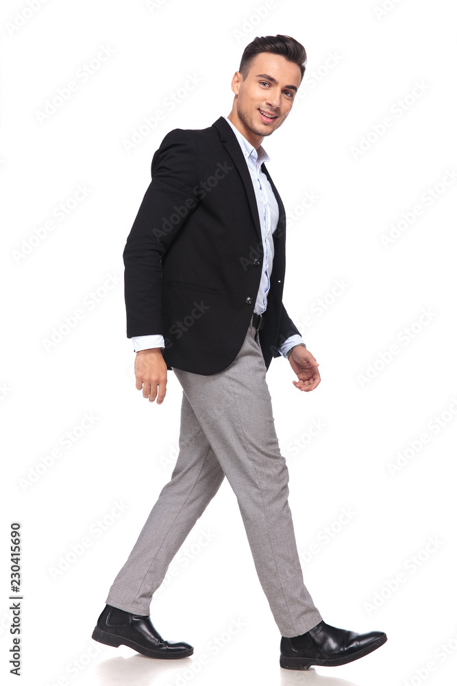 side view of young businessman in black suit stepping side view of young businessman in black suit stepping