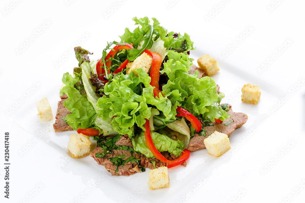Salad with veal and vegetables on a white plate Salad with veal and vegetables on a white plate