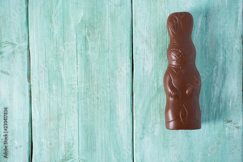 chocolate bunny on turquoise wooden surface