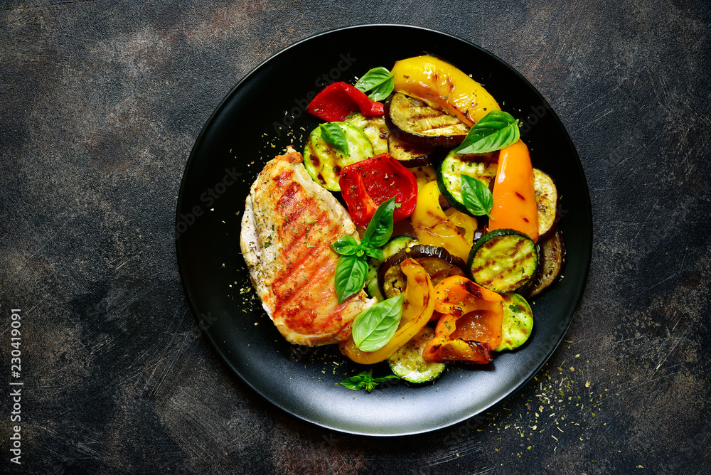 Grilled chiken fillet with vegetables.Top view. Grilled chiken fillet with vegetables.Top view.