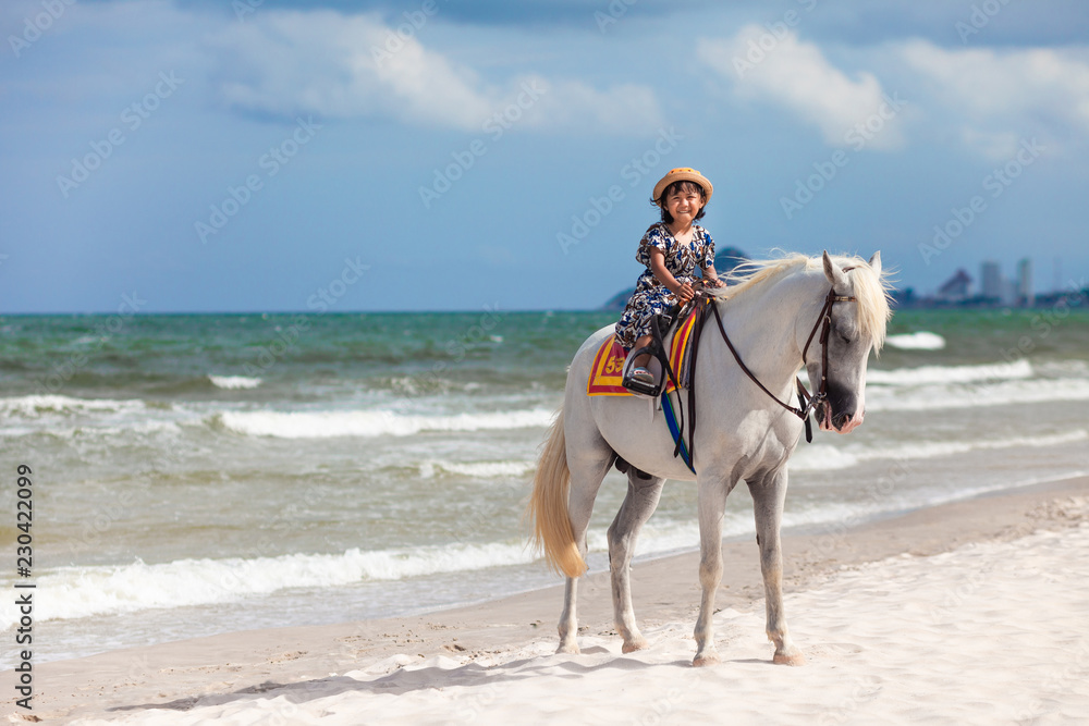 Close up portrait of kids and horse . little girl ride a horse and Tenderness and caring for White horse On the beach. Close up portrait of kids and horse . little girl ride a horse and Tenderness and caring for White horse On the beach.